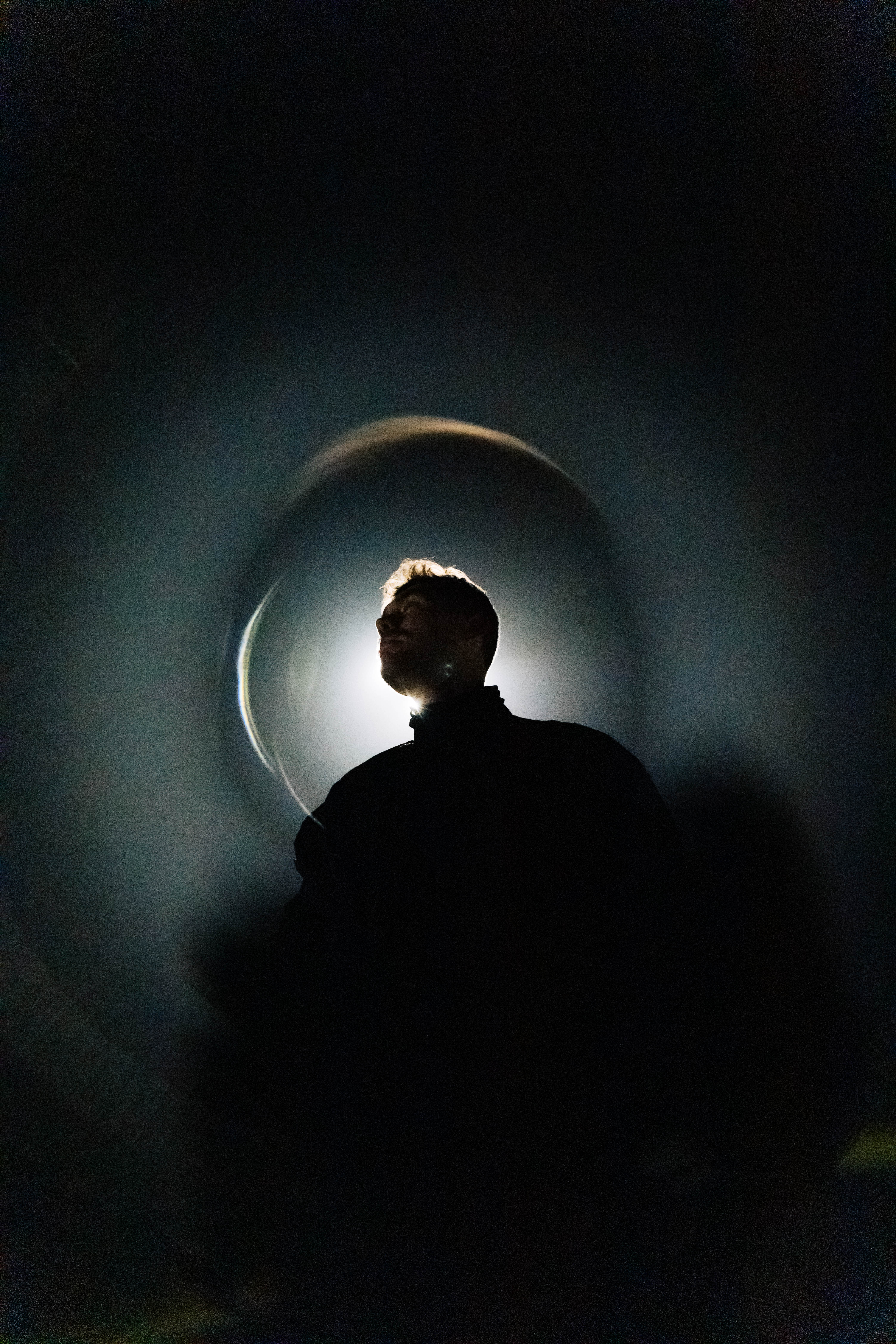 A man standing in front of a light source